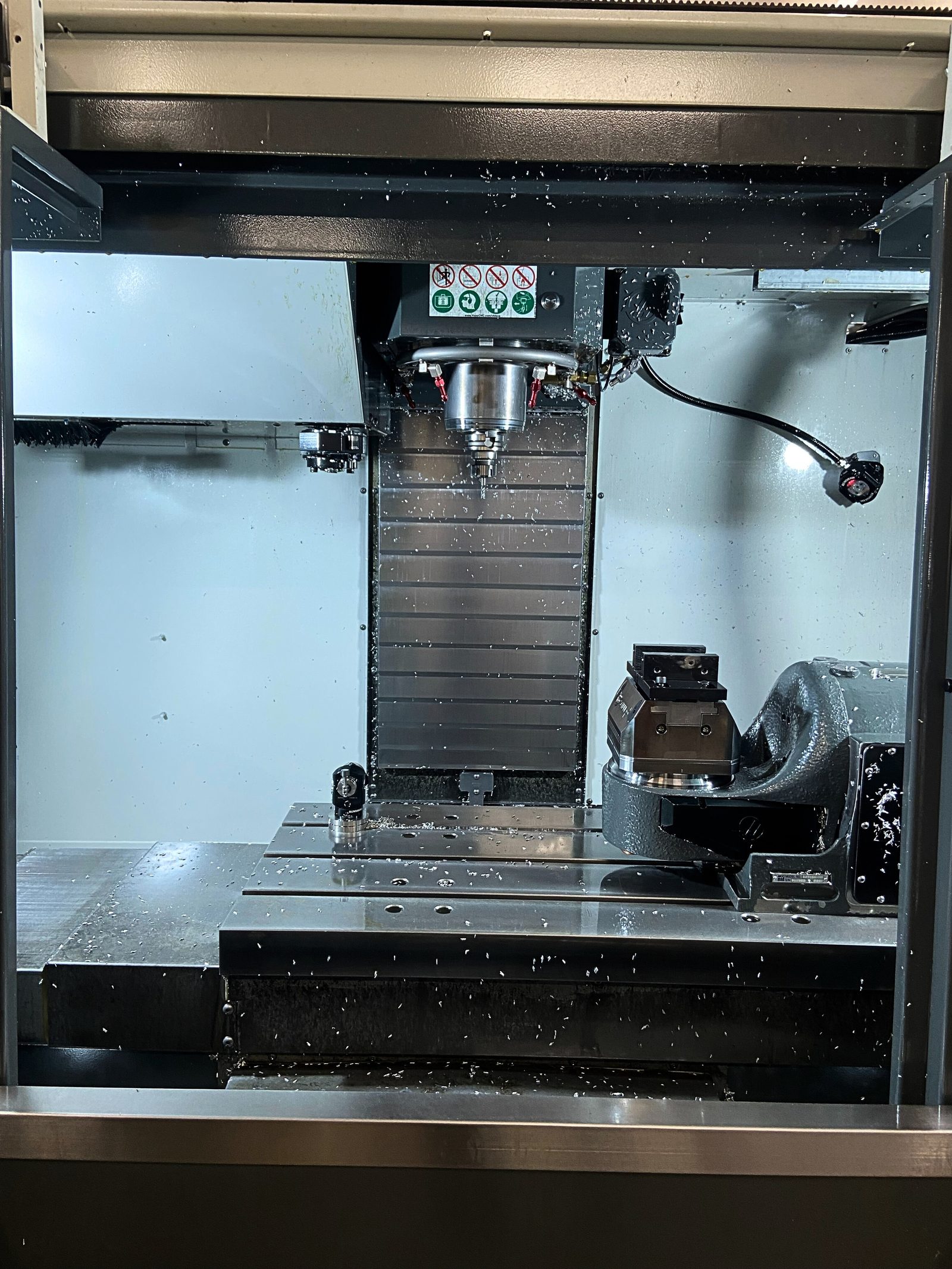 Mandrino del centro di lavorazione verticale CNC in azione su un componente metallico